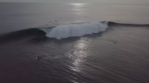 Aerial Shot Of Man Surfing While People Swimming In Sea During Sunset - Siargao, Philippines