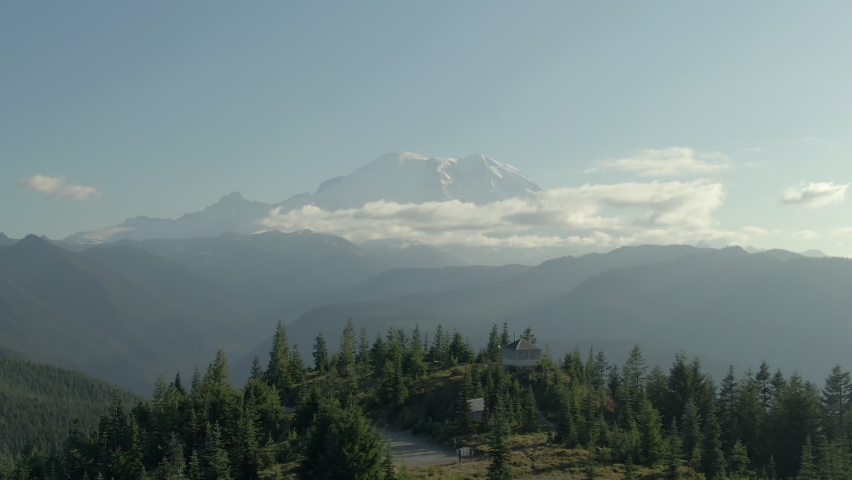 Aerial Panning Shot Of Sun Top Lookout Against Famous Mt Rainier, Drone Flying Forward Over Famous Landmark Against Sky - Seattle, Washington