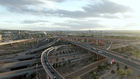 Aerial Tilt Down Shot Of Vehicles On Bridges In City At Sunset Against Sky, Drone Ascending Forward Over Cars In City - Albuquerque, New Mexico