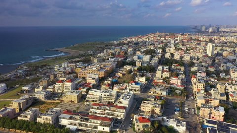 Aerial Shot Of Coastal City By Sea Against Cloudy Sky, Drone Flying Forward Over Residential District - Jaffa, Israel