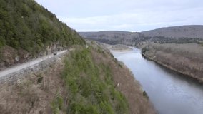 Road between river and mountains in USA, video footage from drone.