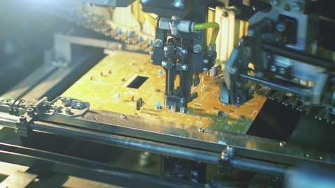 Automated Robot Installing and Soldering an Electronic PCB Circuit Board. Closeup. 4K Resolution.