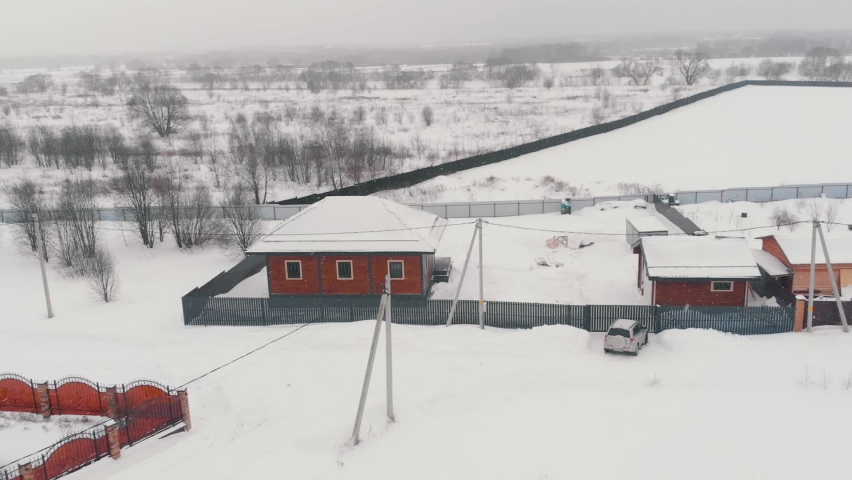 Typical cottage house in rural in winter. Modern country village, house with land plot
