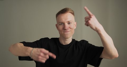 Cool young guy dancing gesturing in camera in studio. Contemporary dance and rap, male hip hop dancer