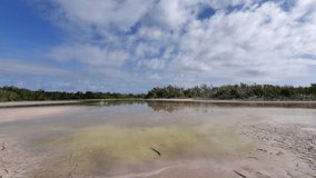 Timelapse of cloud formations moving over and reflected in Eco Pond in Everglades National Park, Florida on calm sunny summer morning 4K.