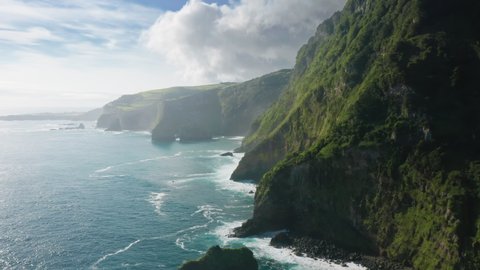 Amazing shot of green mountains of Casa do Gato Tomas surrounded atlantic ocean, Flores Island, Azores, Portugal, Europe. Aerial view of ocean waves crashing of island cliffs, 4k footage 