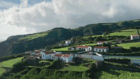Aerial view of Casa do Gato Tomas village surrounded countryside landscape, Flores Island, Azores, Portugal, Europe. Drone shot of houses located on cliffs of atlantic ocean, 4k footage 