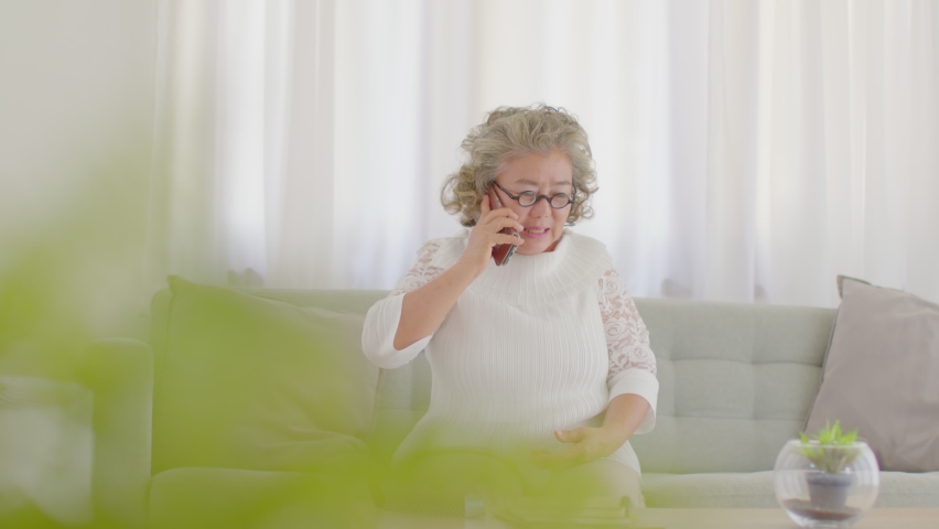 Stress Elderly asian woman white hairs have a problem something and talking with someone in mobile phone to explain her trouble,Pensioner worry with something wrong and struggling with technology  Royalty-Free Stock Footage #1072268165