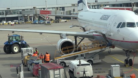 Amsterdam, Netherlands - March 15, 2018: An Aegean airlines aircraft unloading luggage while a TUI airlines plane passes behind it. Netherlands. Amsterdam Airport Schiphol.