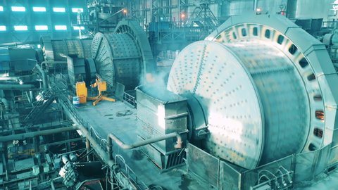 Massive industrial mills are grinding ore at the factory. Mining industrial conveyor at ore processing factory.
