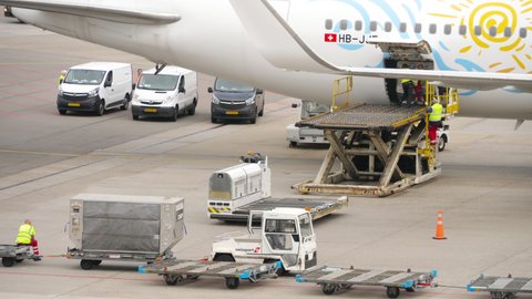 AMSTERDAM, THE NETHERLANDS - JULY 29, 2017: TUI Fly Boeing 767 HB-JJF arrived at the airport, airport staff unload the luggage from the plane, Schiphol Airport, Amsterdam, Holland