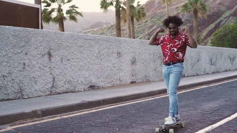 African man having fun with a skateboard on the road