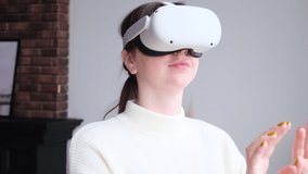 Caucasian woman indoor at home in virtual reality glasses touching air look around   