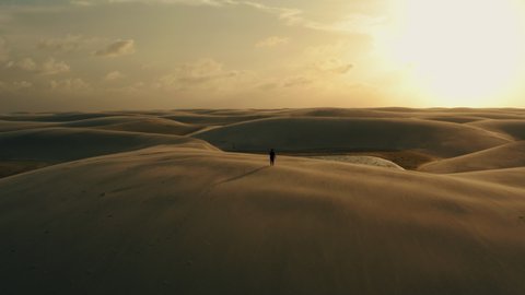 girl walking at sunset north brazil Lençóis Maranhenses dunes paradise desert aerial topview panorma 4k