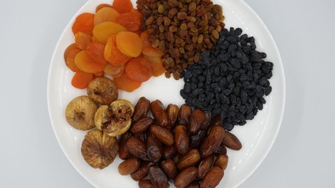 Slowly rotating dried fruits on a plate, top view