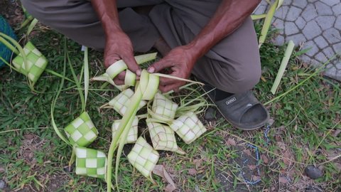 The process of making ketupat wrappers from young coconut leaves is done using two hands. Often found just before the Eid al-Fitr. Sokaraja, Purwokerto, Central Java, Indonesia, May 12, 2021