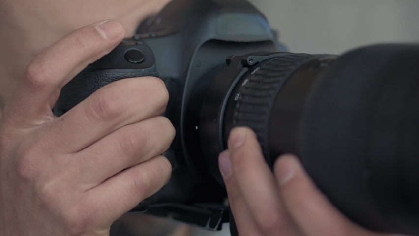 A man takes photos using a SLR camera with a large lens.