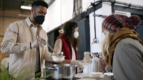 Volunteers serving hot soup for homeless in community charity donation center, coronavirus concept. - Powered by Shutterstock - Get 15% off with code: PIKWIZARD15