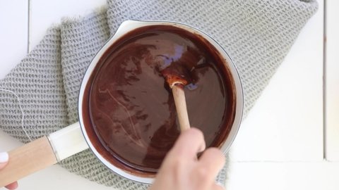 Whisking melted chocolate in white pan
