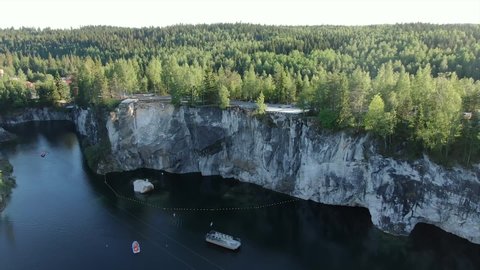 Aerial video: a marble quarry in Karelia from a flight height, in the frame a boat goes through the water in the quarry