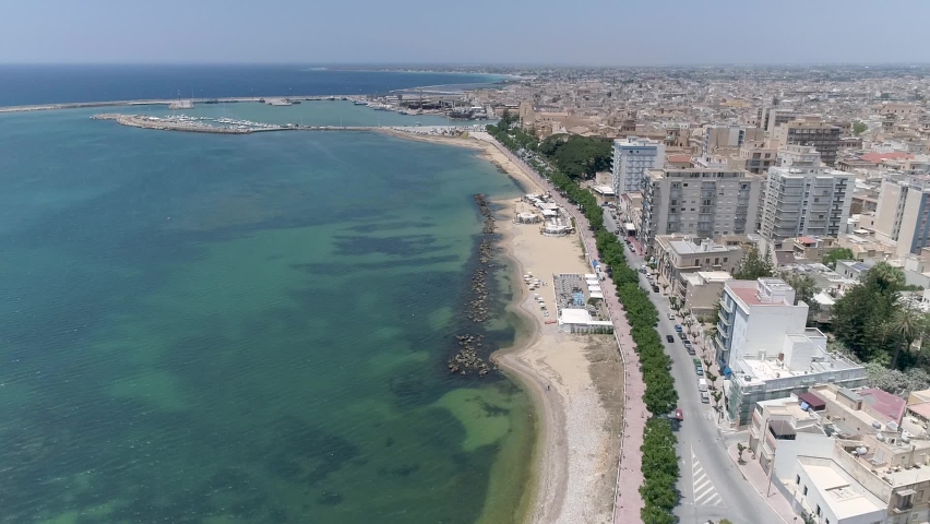 aerial view with a drone of a typical seaside town in Sicily. "Mazara del vallo" in the province of "Trapani", one of the most important fishing ports in Italy, founded around 827 by the Saracens Royalty-Free Stock Footage #1072317683