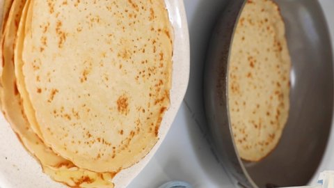 Stacking crepes in a dish from hot pan