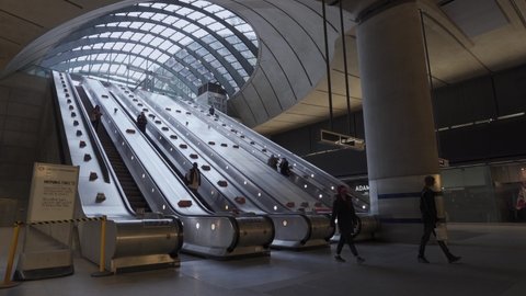 Canary Wharf, London | UK - 2021.05.08: People on the escalator at the Canary Wharf tube Underground station