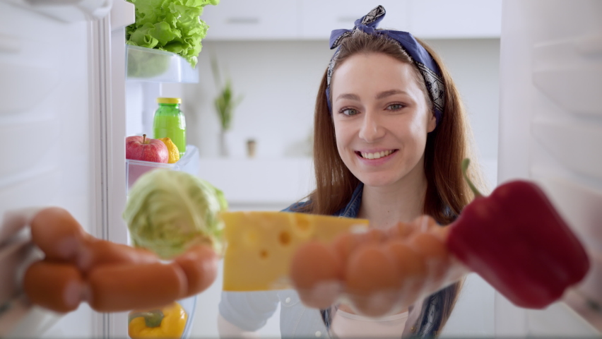 Happy pinup woman looks into an empty refrigerator, but the problem can be solved! Online ordering of goods from the supermarket. Animation of the appearance of goods. View from inside fridge Royalty-Free Stock Footage #1072322681