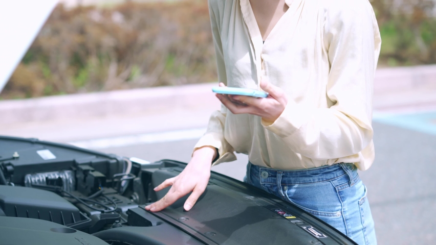 Young asian woman opening bonnet of vehicle. Road service. Roadside assistance. Royalty-Free Stock Footage #1072325654