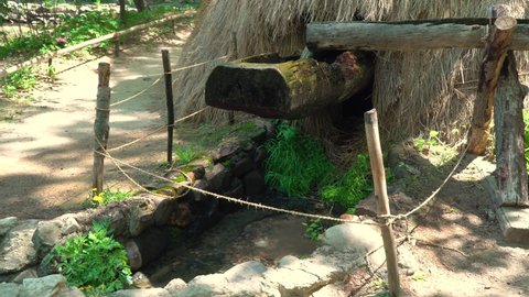 Water Slowly Fills A Hollow On Wood On A Traditional Korean Mill Then Suddenly Tips In Korean Folk Village, Yongin, South Korea. - close up