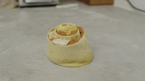 Rolled lasagne on kitchen cooking table. Close up slow motion shot.