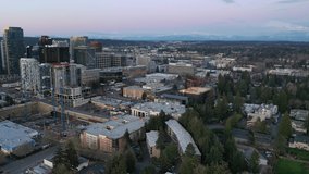 Cinematic aerial drone footage of downtown, city center of Bellevue with skyscrapers, tall office and apartment buildings during the blue hour after sunset near Seattle, Washington