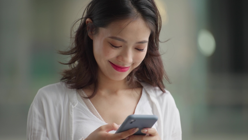 close up slow motion of pretty young asian woman looking at mobile phone in hand people using mobile phone 4k footage Royalty-Free Stock Footage #1072332893