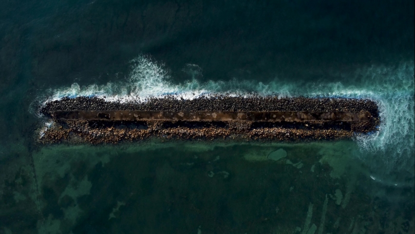 Top down view on breakwater a far from the beach in Nusa Dua Bali Indonesia. High quality aerial birds eye drone 4k footage | Shutterstock HD Video #1072343375