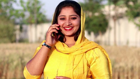 New Delhi, India - April 08, 2021: Pretty lady using mobile phone outdoor in nature.