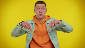 Look at advertisement! Teen stylish boy pointing down, saying to subscribe, gesturing ok and like, showing place for commercial, promotional information below. Young man on yellow studio background - Powered by Shutterstock - Get 15% off with code: PIKWIZARD15