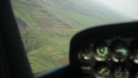 View from the plane window. Flying over fields, villages, beautiful nature from a bird's-eye view. The sporty four-seater aircraft flies in the air. Air walk. Plane turns