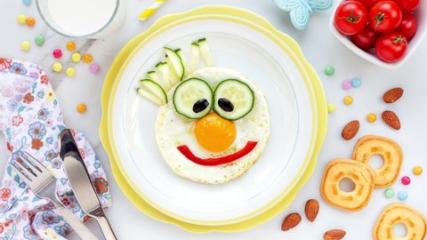 Cute and smiling Fried egg clown preparation for kids breakfast or lunch in stop motion animation