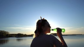 slow motion video of a girl drinking mineral water at sunset 120 fps