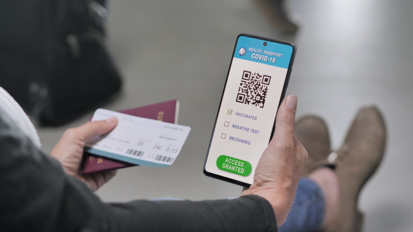 female traveller waiting for boarding holds health passport and boarding pass,woman sits at the airport holding digital covid-19 vaccination certificate on smart phone screen,green card travel
 Royalty-Free Stock Footage #1072381193