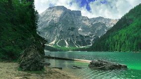 Flying above clear turquoise water on a famous alpine lake Lago di Braies ,Dolomites,Italy. Mountain ranges. fresh dense forest natural Landscape. - Powered by Shutterstock - Get 15% off with code: PIKWIZARD15