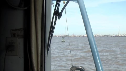 Ship Approaching to an Automated Harbour Light Buoy powered with Solar Panels in the Rio de la Plata River, near Buenos Aires, Argentina, South America.  