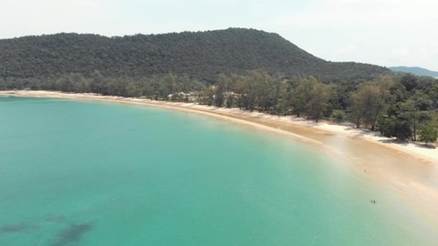 Golden sand beach sidelining the clean crystal turquoise water of M'pai Bay, in Koh Rong Sanloem Island, Cambodia - Aerial Fly-over shot
