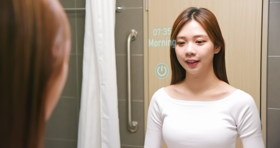 Asian woman looking and touching smart screen at bathroom while waking up - Using Health app analyzing the sleep from a tracker and showing the data. Royalty-Free Stock Footage #1072384022
