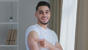 Portrait of arabic ethnic hispanic man guy patient shows medical plaster on shoulder demonstrates injection mark happy satisfied after vaccination with covid-19 virus vaccine smiling looks at camera - Powered by Shutterstock - Get 15% off with code: PIKWIZARD15