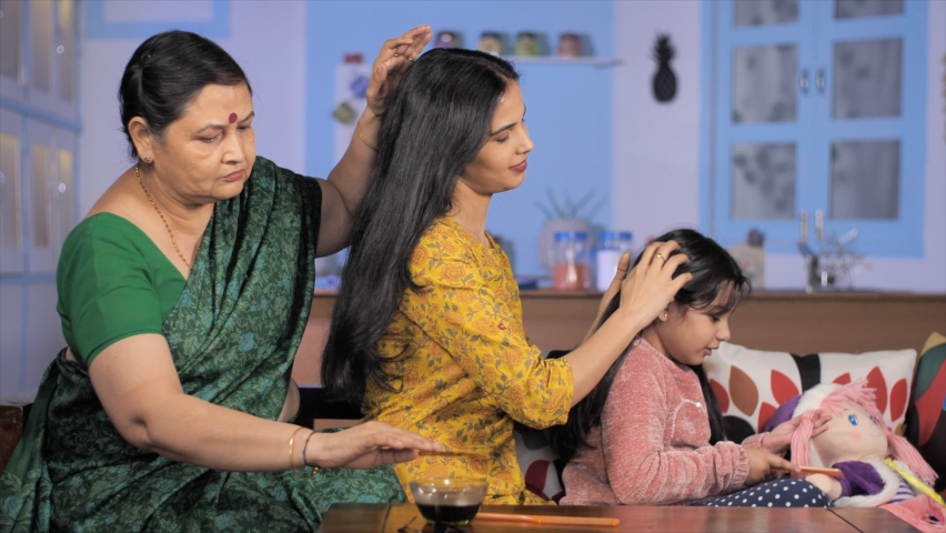 Three generation women oiling each other's hair - healthy hair. Indian family bonding. Medium shot of an adorable little girl combing her doll's hair - stylish haircare and fashion concept Royalty-Free Stock Footage #1072392182