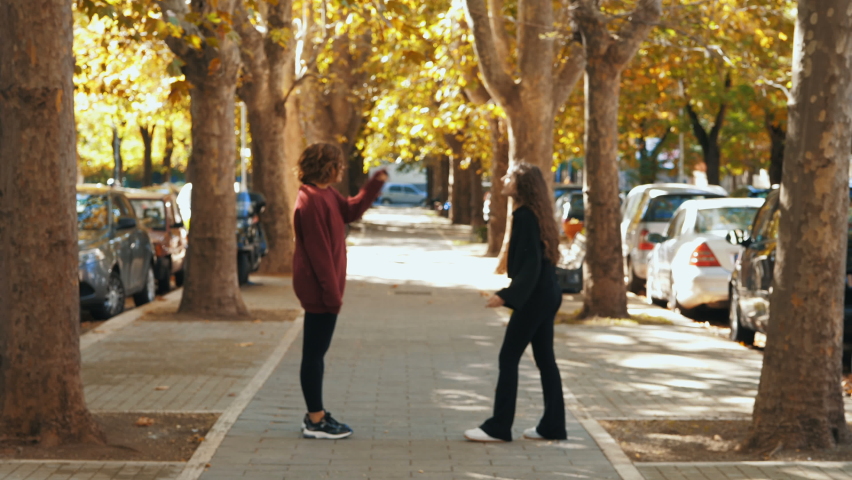 quarrel between friends - two girls argue in the street and one slaps the other