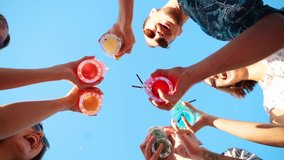 Low angle view of friends having fun at pool party, clinking glasses with colorful summer cocktails near hotel swimming pool. People toast drinking fresh juice at luxury summer villa in slow motion. - Powered by Shutterstock - Get 15% off with code: PIKWIZARD15