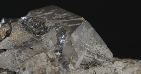 Pyrite dodecahedral crystals on hematite (also known as fool's gold or iron pyrite), isolated on a black background