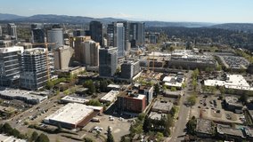 Cinematic aerial drone clip of the city center, commercial district of Bellevue near Downtown Park and Bellevue Square, skyscrapers, office and apartment buildings near Seattle, Washington